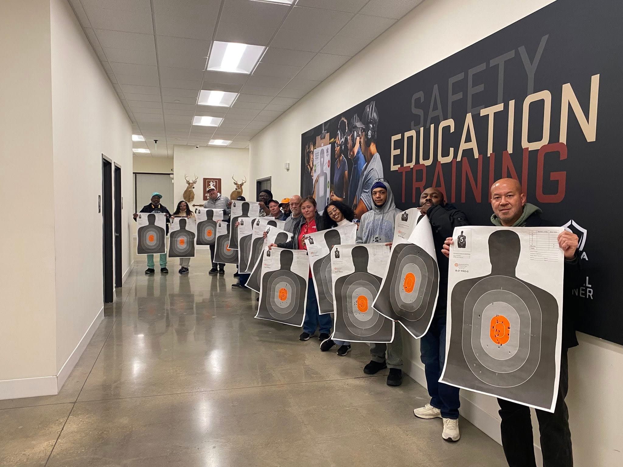 Students holding shooting targets after completing a Maryland CCW class with Paradigm Firearms Training in Westminster, MD